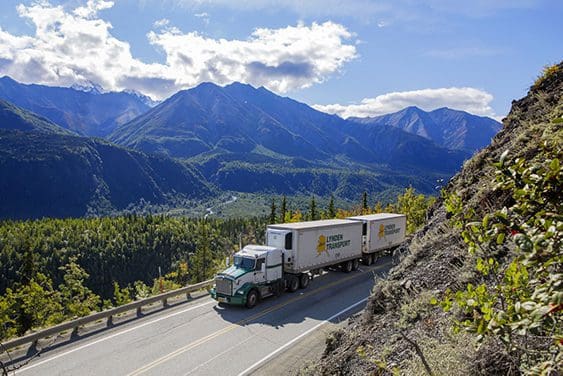 Full truckload transporting goods through mountain pass.